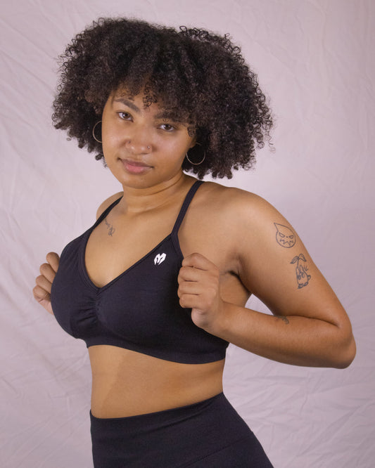 Model posing against plain white background in GYMPIRE Sports bra